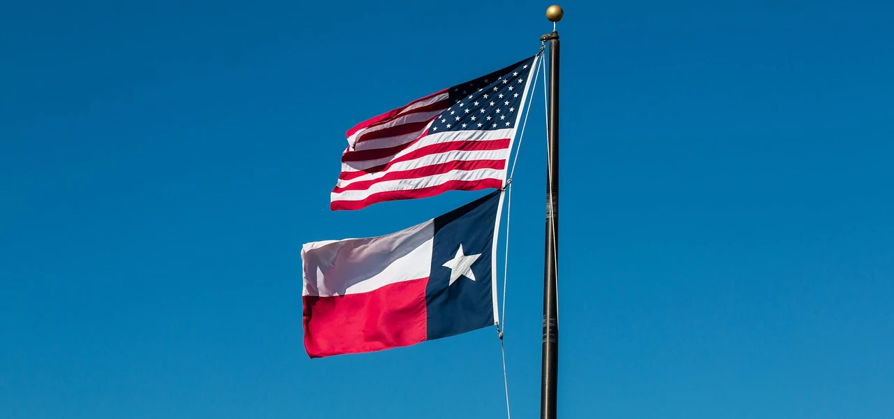 Die US-Flagge und die Flagge von Texas am selben Flaggenmast