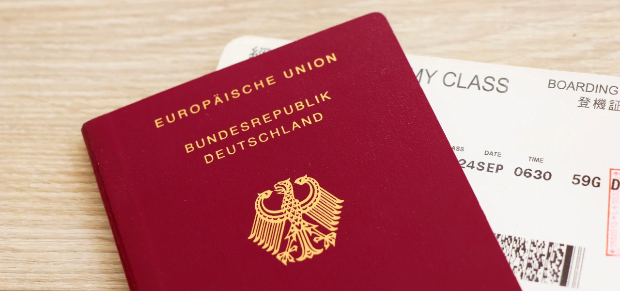 Ein deutscher Reisepass mit einem Flugticket im Hintergrund